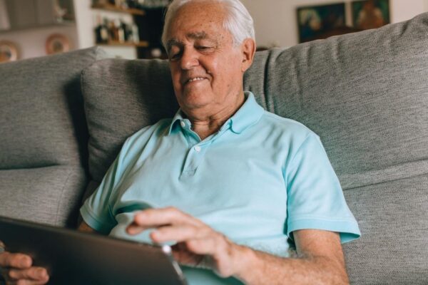 An older adult using technology to manage daily tasks at home, promoting independence and comfort.