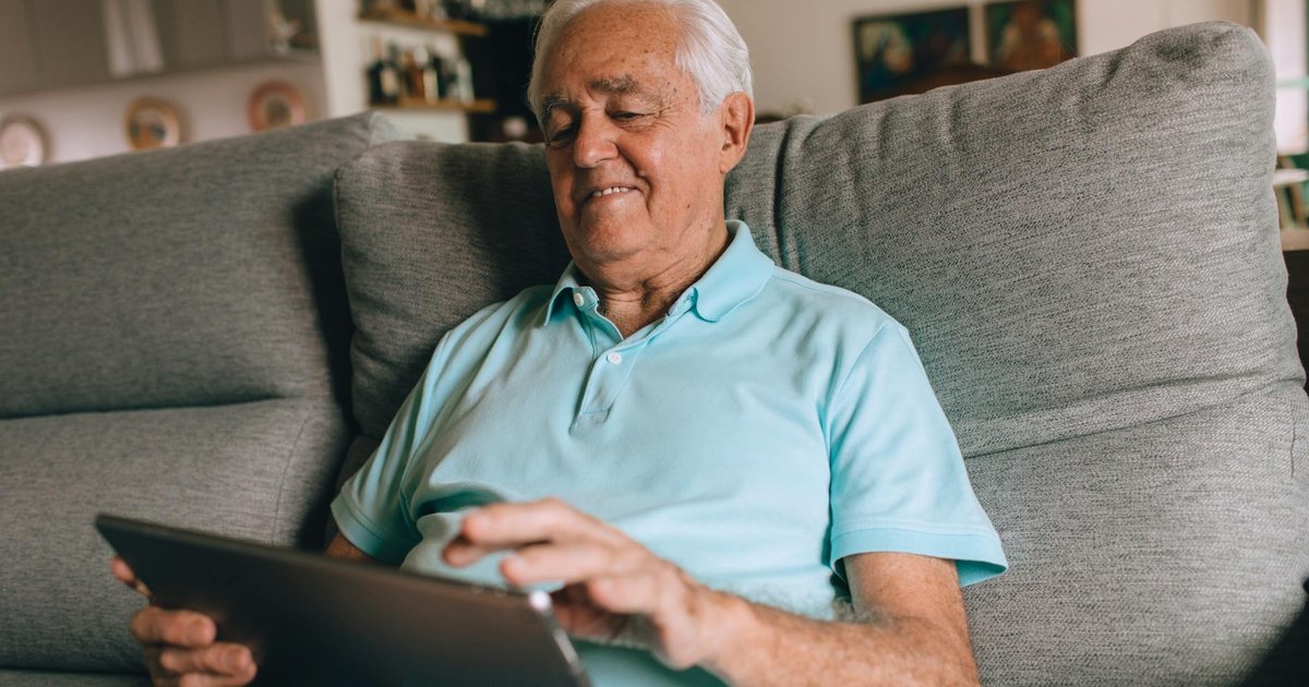 An older adult using technology to manage daily tasks at home, promoting independence and comfort.