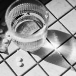 Aspirin and a glass of water, highlighting health research on cancer prevention.