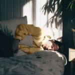 Person in bed holding stomach, highlighting the impact of Clostridioides Difficile infections.