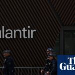 Protesters holding signs against Palantir's contracts with the UK government.