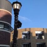 A cityscape depicting surveillance cameras as cities reconsider Flock technology.