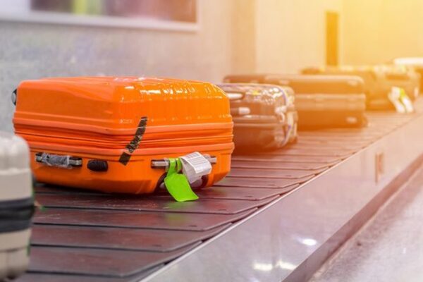 A traveler checking in luggage at an airport with a co-branded airline credit card