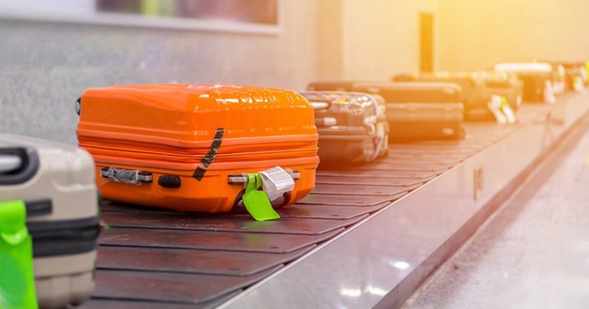A traveler checking in luggage at an airport with a co-branded airline credit card
