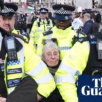 Demonstrators in Trafalgar Square holding signs supporting Palestine Action during the protest.