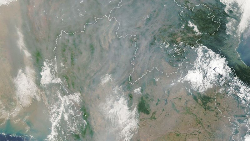A satellite image shows gray smoke obscuring most of the landscape around Chiang Mai except for small areas where mountain ridges are visible.