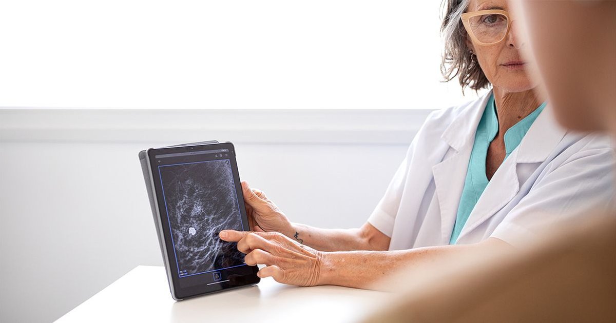 Doctor reviews medical scans with a patient discussing cancer risks related to obesity.